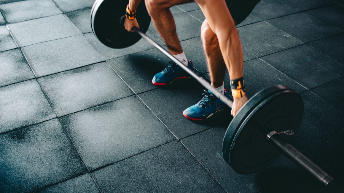 person holding black barbell